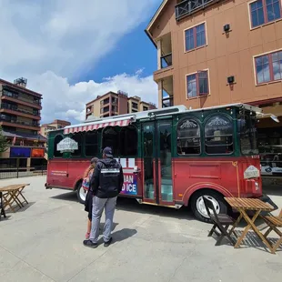 a man standing in front of a red bus