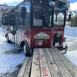 a red trolley parked in a parking lot