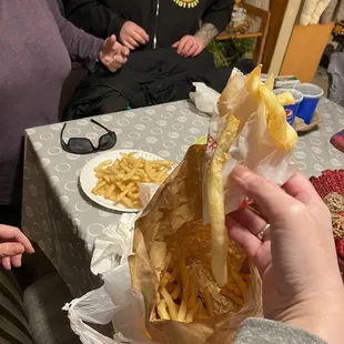 a person holding a bag of french fries