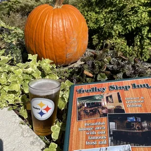 a glass of beer next to a pumpkin