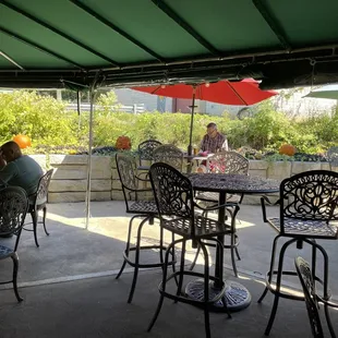 people sitting at tables under umbrellas