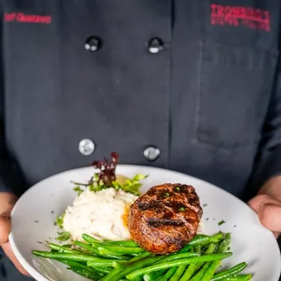 a chef holding a plate of food