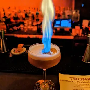 a cocktail with a blue flame coming out of it