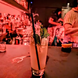 a cocktail in a tall glass on a bar counter