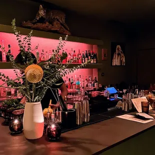 a vase of flowers on a bar counter