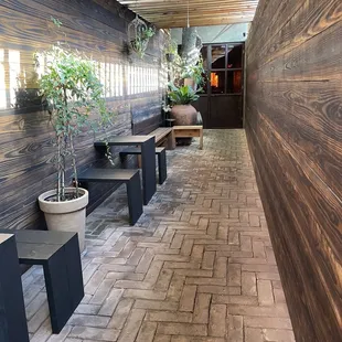 Half outdoor seating area, just within the gate but not quite within the enclosed building itself (the whole bar is one long hallway)