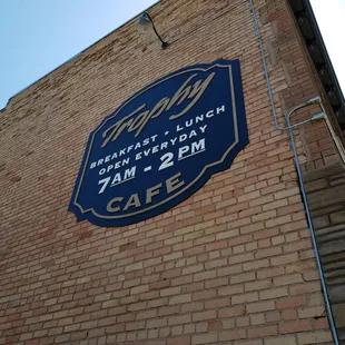 a blue sign on the side of a brick building