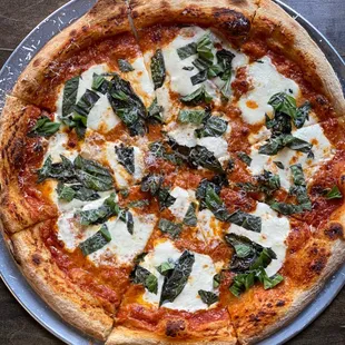 a pizza with cheese and spinach