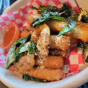 Fried mozzarella sticks with fried basil and lemon slices