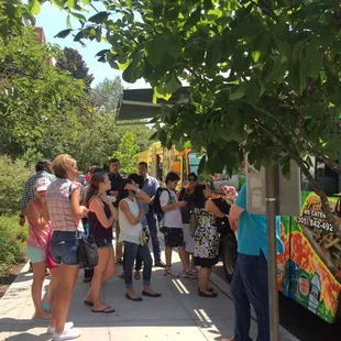 a line of people waiting for a food truck