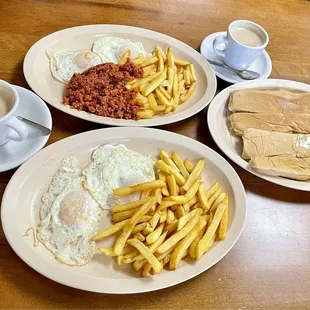 Fried eggs, chorizo(in the rear) with fries, pressed buttered bread and coffee