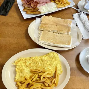 Cheese omelette and tropical special with fried eggs, ham, bacon and sausage with pressed buttered bread