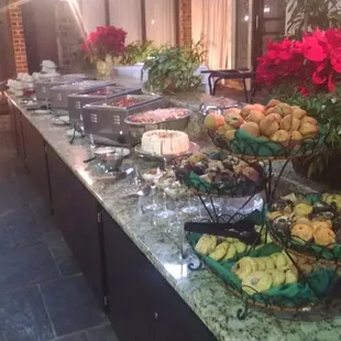 a buffet table with fruit and flowers