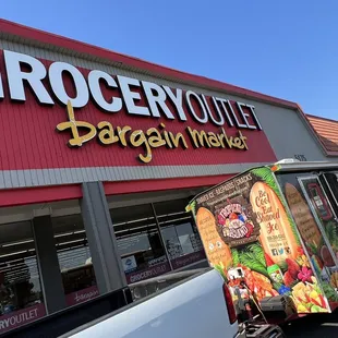 a grocery outlet with a truck parked in front of it