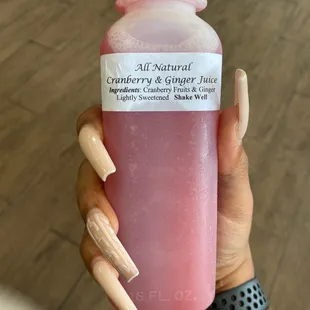 a hand holding a bottle of juice