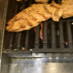 chicken on a grill being cooked