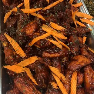a tray of chicken wings and carrots