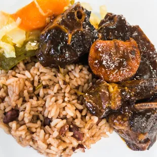 a plate of rice, meat, and vegetables