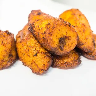 a pile of fried bananas on a white plate