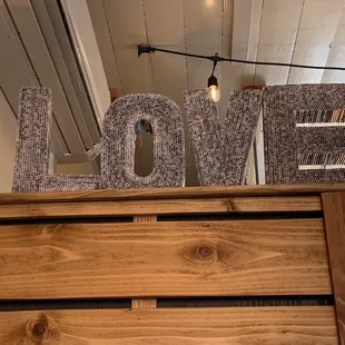 "LOVE" art made with magazine pages rolled into tubes