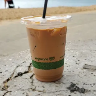 a cup of iced coffee on the beach