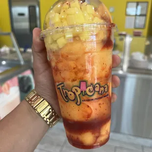 a hand holding a cup of ice cream