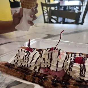 Churro Split with coconut ice cream, strawberry and chocolate ice cream. In the back ground cone ice cream with Ferraro rocher ice cream