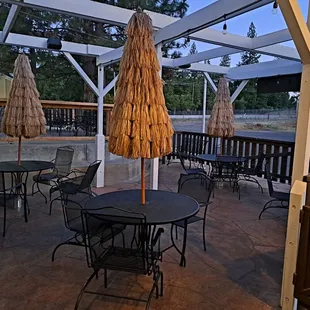 Outdoor patio has 8 tables. These 4 tables have fun tropical themed umbrellas.