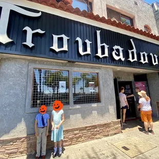 a group of people standing outside of a restaurant