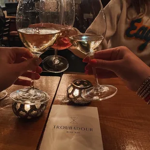 two people clinking glasses of wine