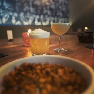 a bowl of nuts and a glass of beer