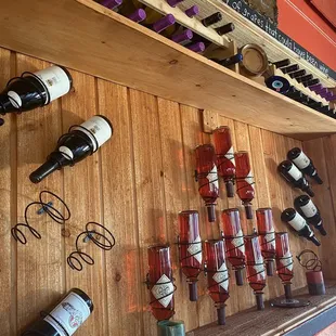 wine bottles and wine glasses on a wall