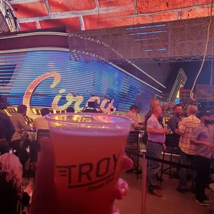 a hand holding a pint of beer