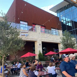 people sitting at tables outside a restaurant