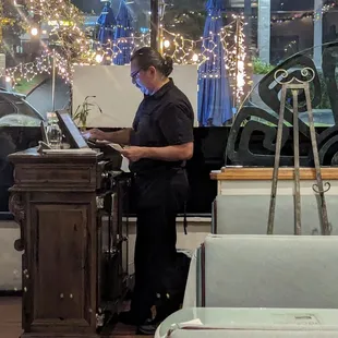 My waiter Ricardo tabulating the bill. Five star, impeccable service at Troy&apos;s Greek Restaurant December 28th, 2023.