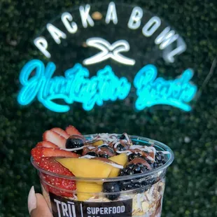 Custom bowl with blue majik base and topped with strawberries, blueberries, mango, blackberries, coconut, and cacao drizzle