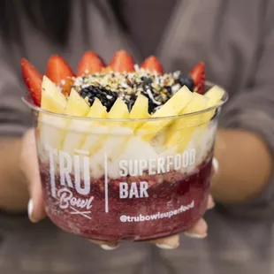 a woman holding a bowl of fruit