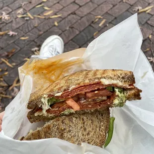 a person holding a sandwich in a wrapper