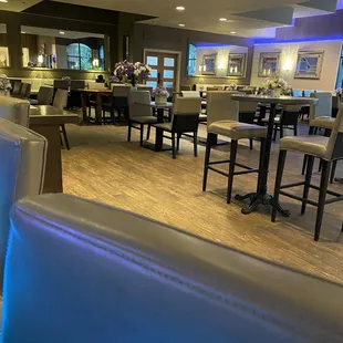 a dining area with a bar and chairs