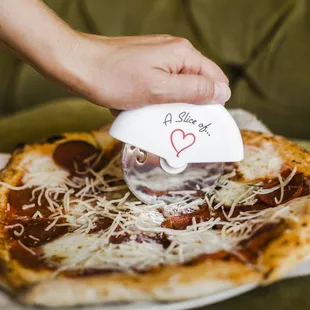 a hand holding a piece of pizza