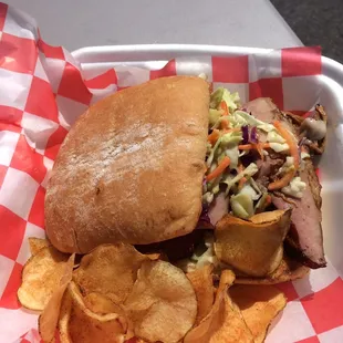 Cuban carnitas - slow roasted pork with Mexican spices, swiss cheese, ham, homemade pickles and a tasty slaw on a ciabatta roll.