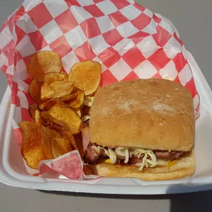 a sandwich and chips in a styrofoam container