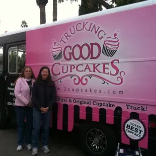 two women standing in front of a truck