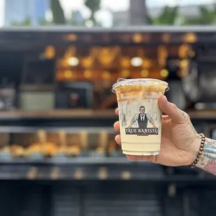 a hand holding a cup of iced coffee