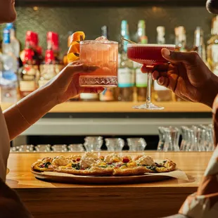 two people toasting at a bar