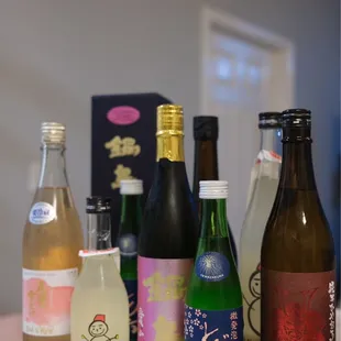 a variety of sake bottles on a counter