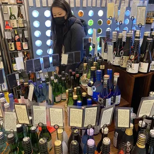a woman looking at bottles of alcohol