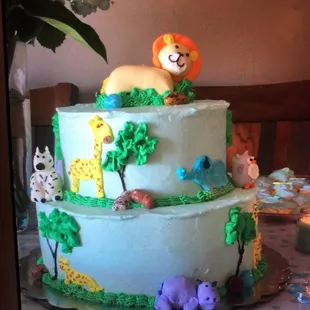 a three tiered cake decorated with jungle animals