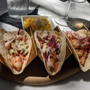 three tacos with shrimp, corn, and slaw