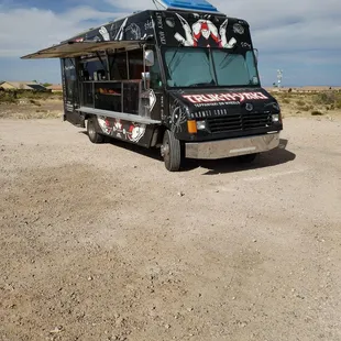 ows a food truck parked in the desert